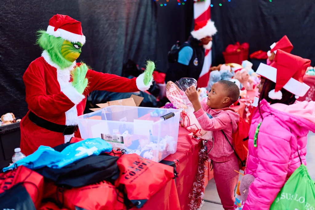 A child receiving a gift from the Grinch at Winter Wonderland