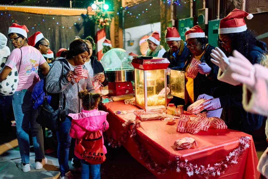 Volunteers serving popcorn and holiday treats